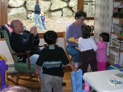 Mia opening gifts with Ron, Gabriel, Anna, and Mom (Isabella and Karen in window)