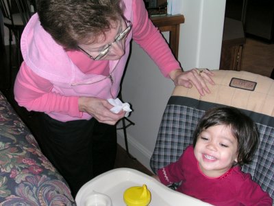 Mia laughing in high-chair with Grand-Mom