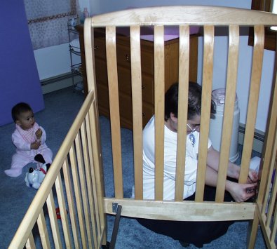 Mom lowering the crib's mattress