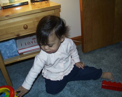 Mia playing by bed table