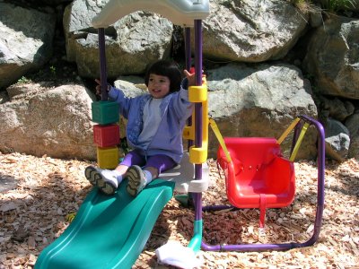 Mia outside on the swing set