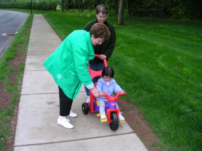 Mia on her tricycle with Mom and Grandmom