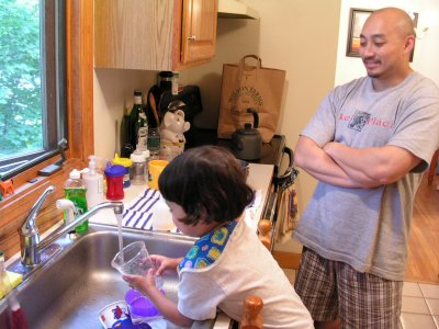 Mia washing dishes with Uncle Ron