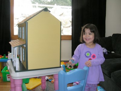 Mia smiling by her new doll house