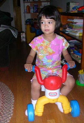 Mia on a toy tricycle