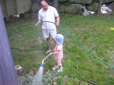 Mia watering plants with Daddy
