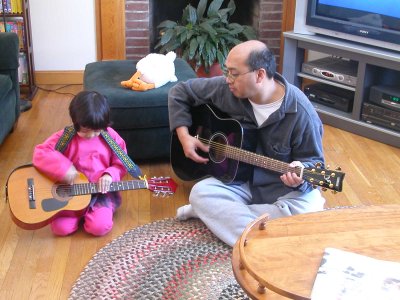 Mia playing her guitar with Daddy