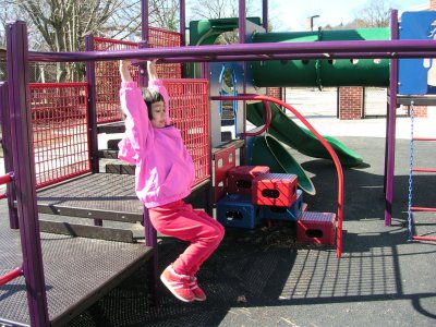 Mia swinging on the monkey bars