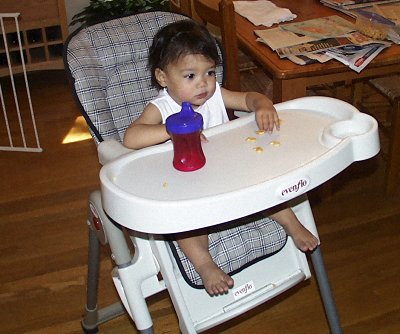 Mia snacking in her high chair