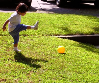 Mia kicking a ball