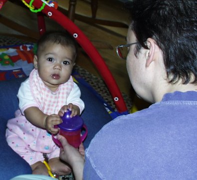 Mom giving Mia a sippy cup to try