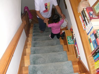 Mia walking down the stairs with Dad's help